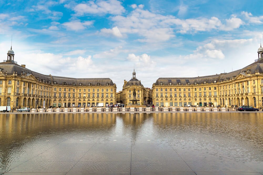 the place de la bourse surrounded by a reflecting pool that shines back the architecture in the pool as a reflection