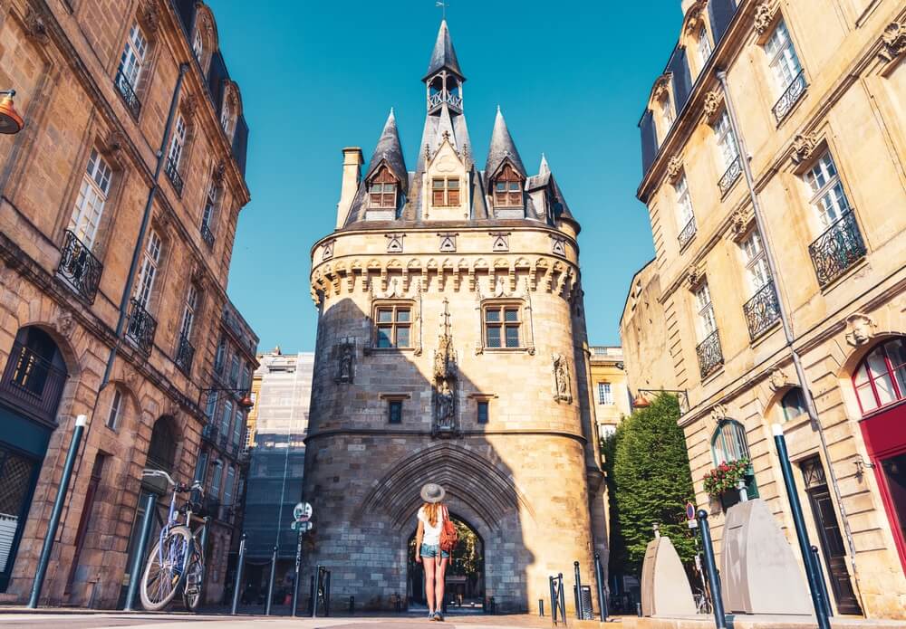 person looking up at a gate in the city of bordeaux