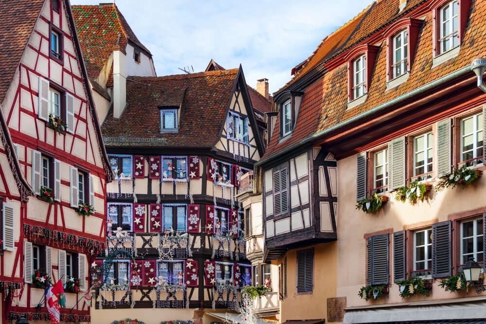 the wintry display of christmas themed decorations in colmar france part of alsace region, three buildings with festive decorations