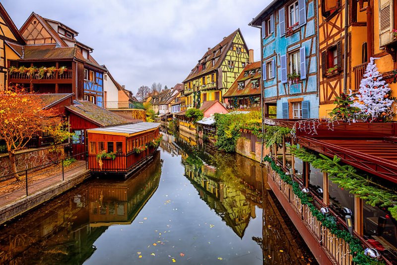 Colmar Old Town in Alsace, France on a cloudy day in winter with traditional colorful half-timbered houses in little Venice quarter, decorated for Christmas