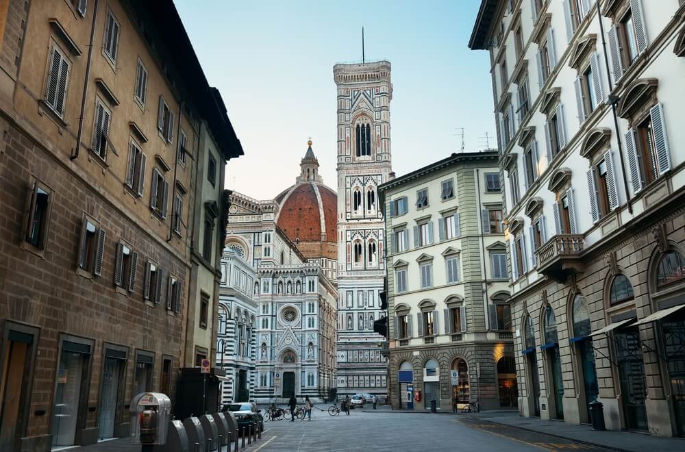 view of the florence duomo from far away showing the bell tower and other important buildings in the complex