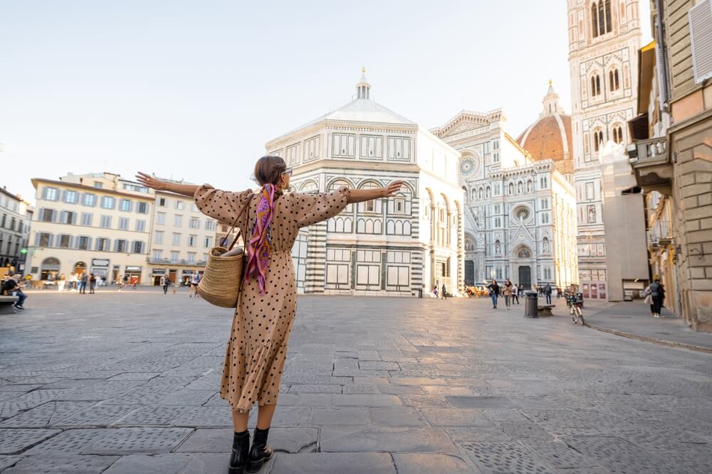 florence duomo outfit with woman with outstretched arms enjoying the beautiful florence cityscape