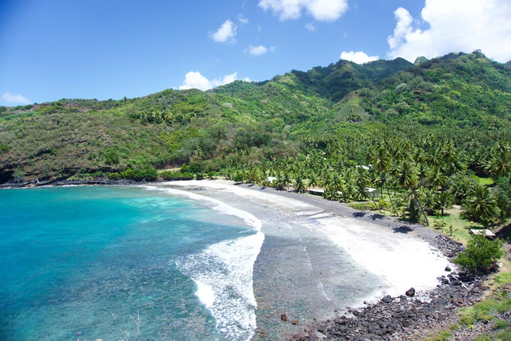 Bay in west coast of Hiva Oa, Marquesas Islands stunning turquoise water and green island and blue sky