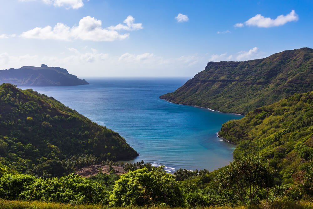 View of the ocean bay on the island of Nuku Hiva, French Polynesia, with gorgeous blue skies and stunning turquoise waters in the bay