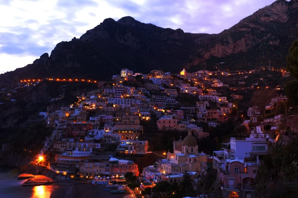 evening in positano with the lights coming on over the town