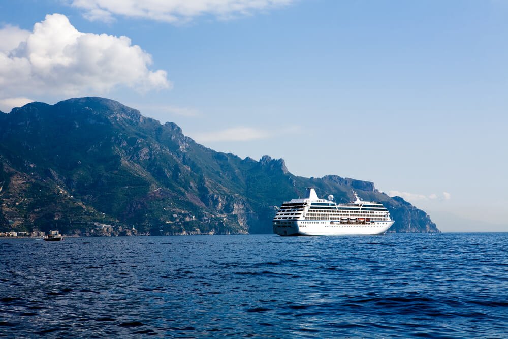 view of a cruise ship on the water with a view of the amalfi coastline