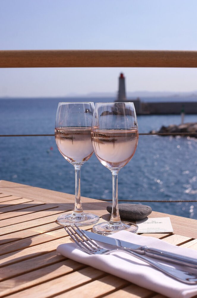 two glasses of rose served at a table overlooking the sea