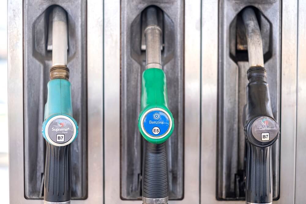 signs for supreme, benzina, and diesel fuel at a gas station in italy