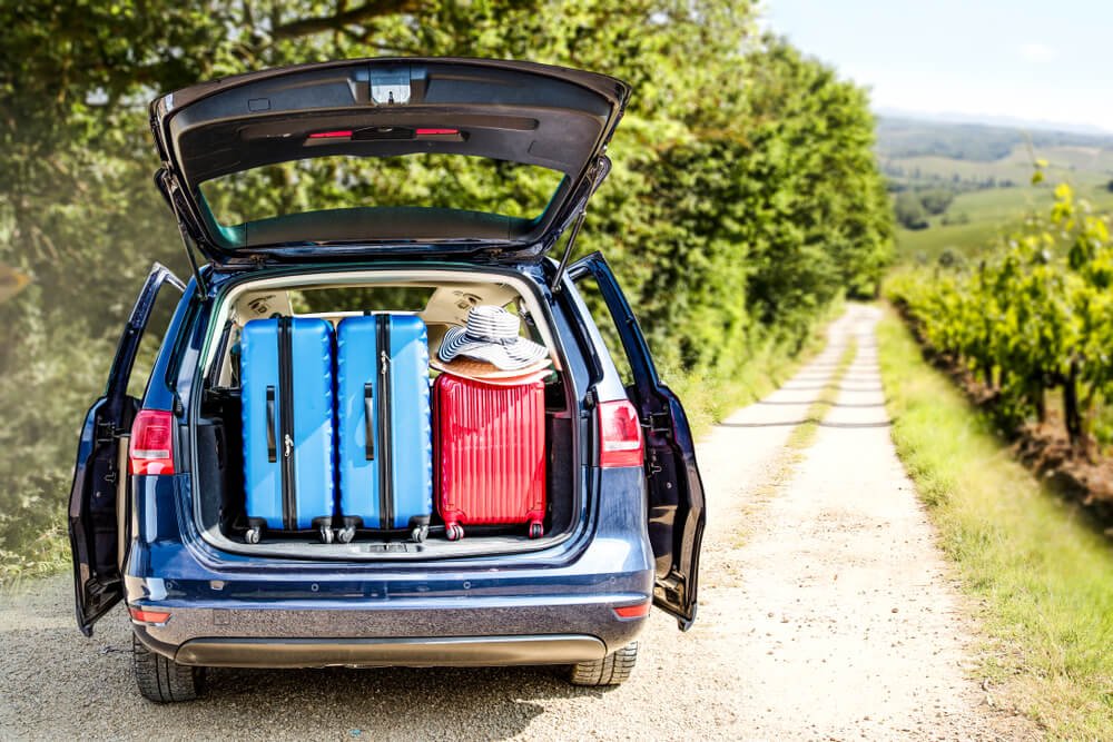 very full car packed with suitcases on the side of an italian road