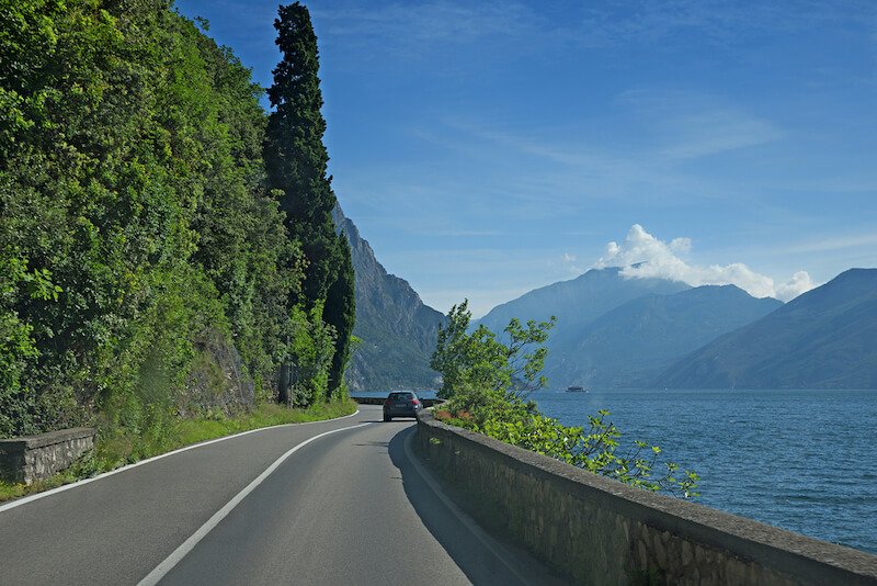 car driving at gardesana occidentale, coastal road along garda lake, italy
