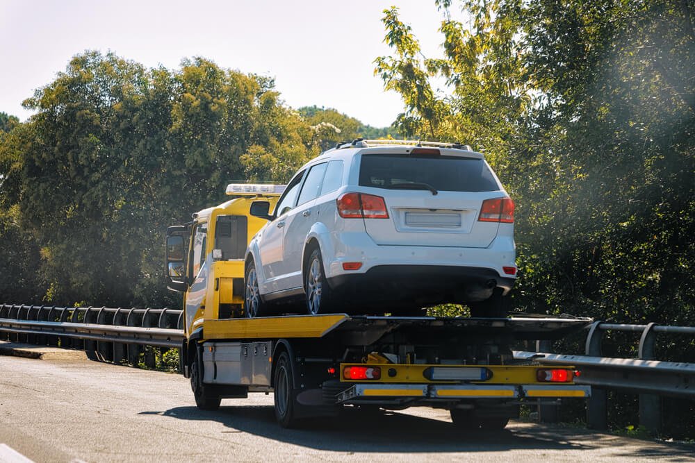 Tow truck with a car on the road in Italy when the car broke down