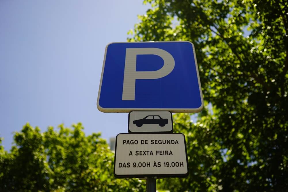 A closeup shot of a parking sign on a blue background with text on Portuguese in Lisbon, Portugal