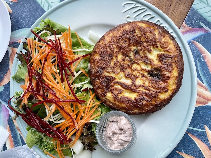 a spanish tortilla with a salad with shredded beet and carrot in roatan