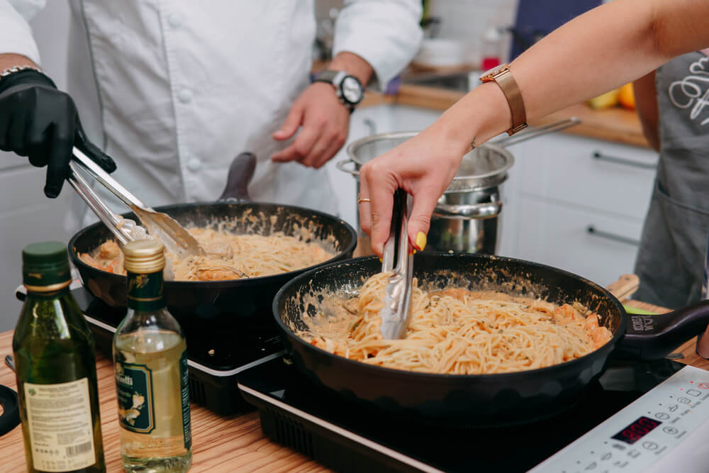 Cooking pasta with seafood in a cooking class. Italian pasta with seafood. Mussels, squid, shrimp.
