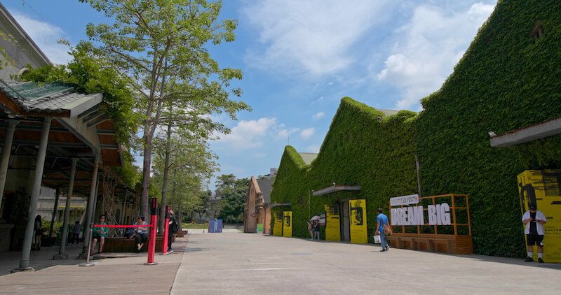 one of taipei's creative parks with ivy-covered buildings and a few people walking out and about