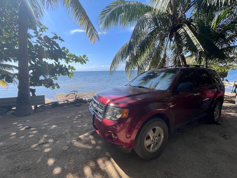 A car by the ocean in Roatan on a beautifully sunny day