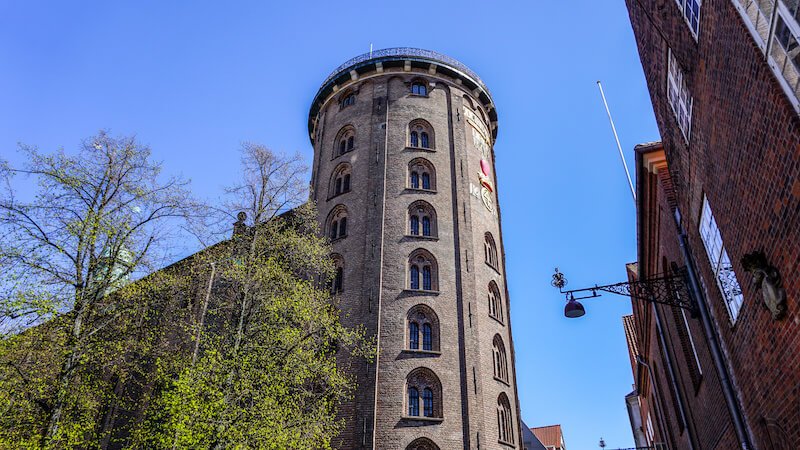 Rundetaarn, Round Tower in Copenhagen, Denmark with green trees and blue sky in the city center