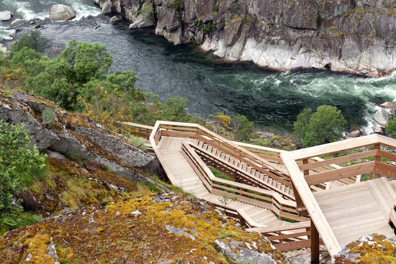 the rushing river in arouca near the wooden staircase walkway