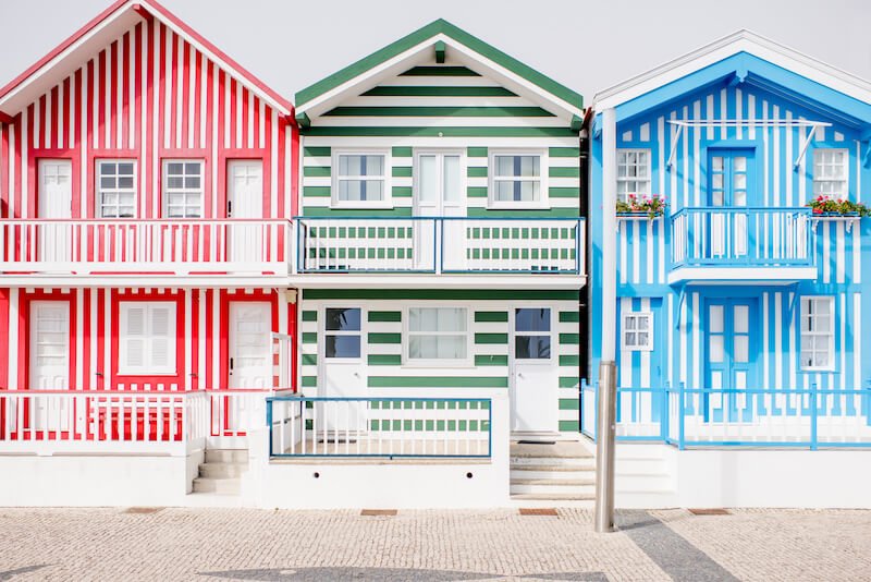 Red house with vertical white stripes, blue house with vertical white stripes, green house with horizontal white stripes