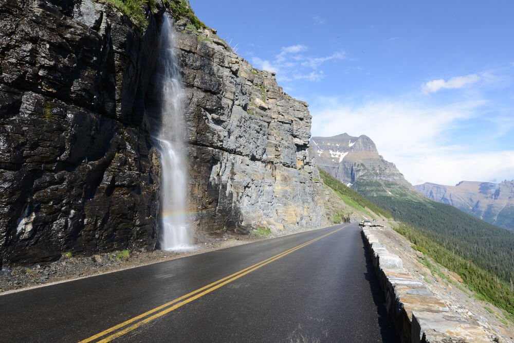 landscape view of a waterfall along the going to the sun road in glacier national park in montana