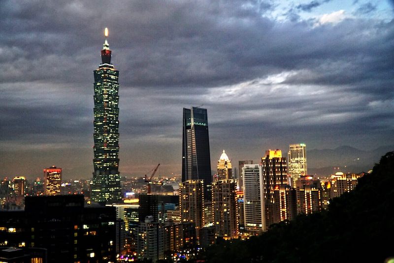 the view of taipei 101 and taipei skyline from elephant mountain after dark with all the city lights on