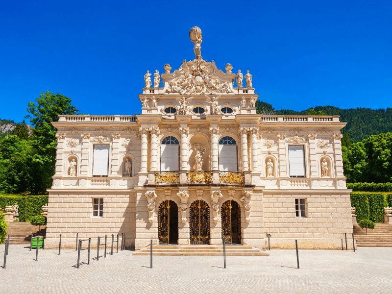 taupe stone building of the facade of the linderhof palace in bavaria on a summer day with lots of ornate detailing on the facade