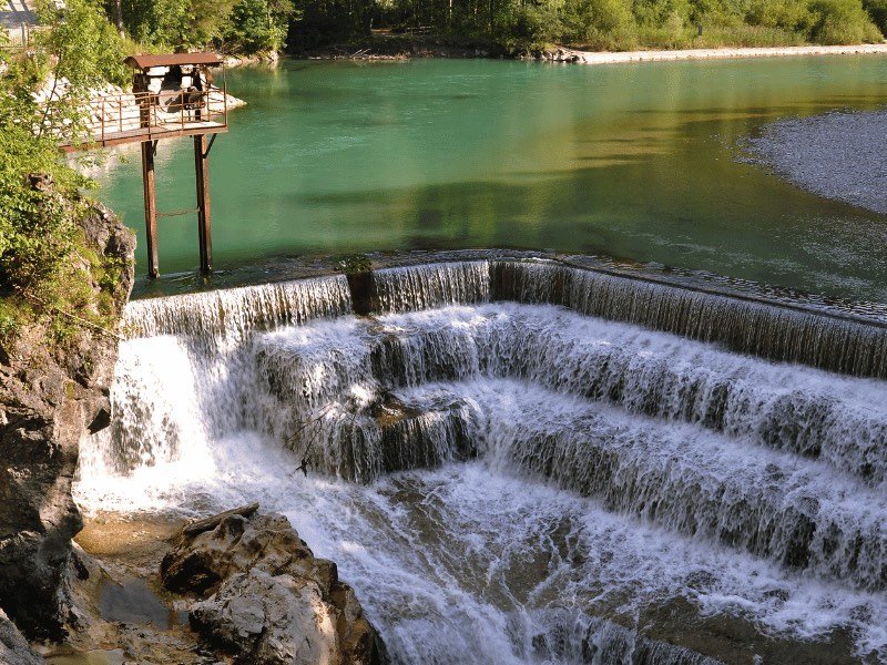 A manmade waterfall called Lechfall with a series of what look like stairs and a river called lech going over it