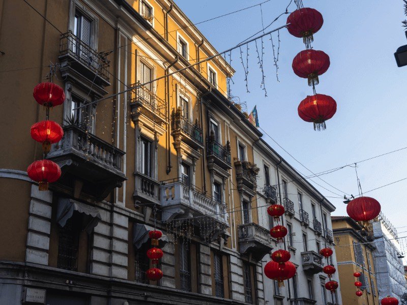 chinese style red lanterns hanging against the backdrop of milanese architecture in the city center, one of the best places to stay in milan