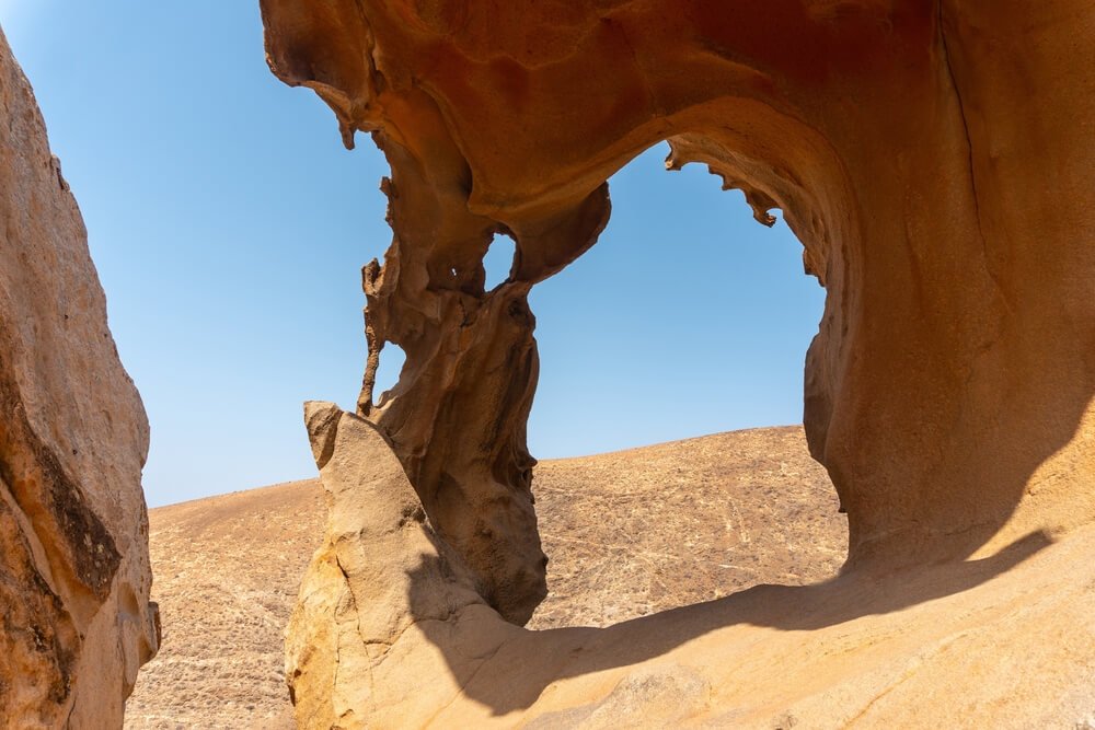 view from the Arco hike in betancuria with an arch in the sandstone that is beautiful