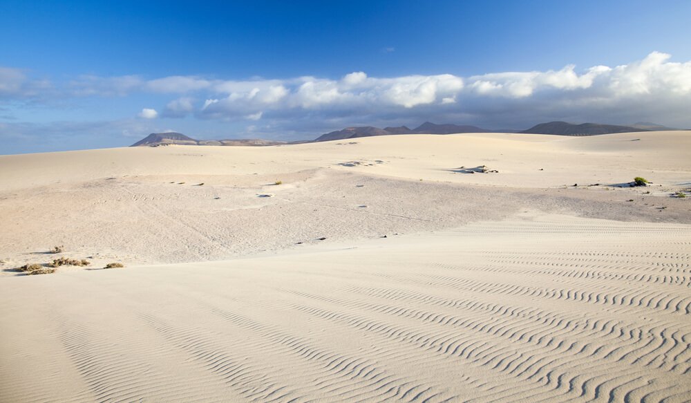 the corralejo sand dunes with beautiful white sand and blue sky