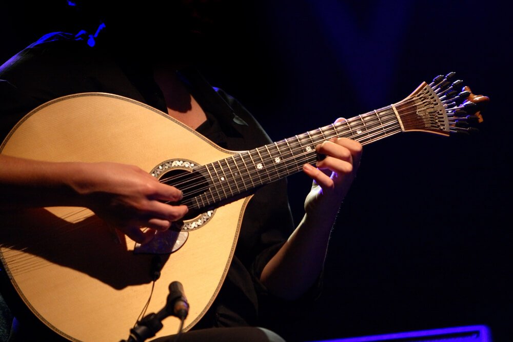 "fado" - performer playing a tradicional portuguese guitar in the dark 