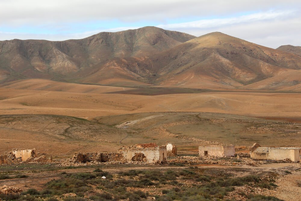 Abandoned village at La Florida, Fuerteventura, with desert landscape and mountains behind it