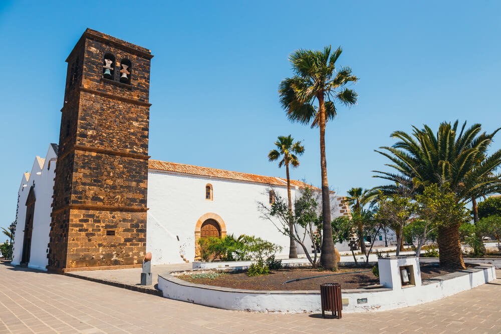 Church of Our Lady of Candelaria in La Oliva, Fuerteventura Island, Spain, with colonial architecture and palm trees on a sunny day