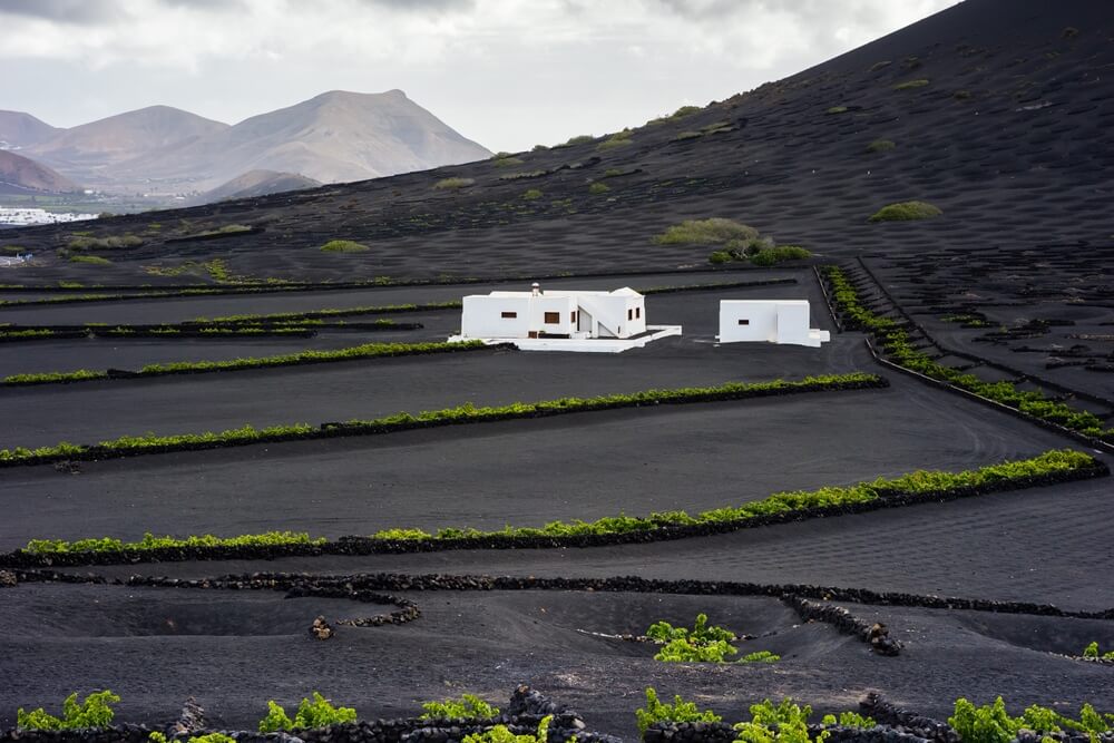 white building stark against a black volcanic landscape in an exercise in contrast