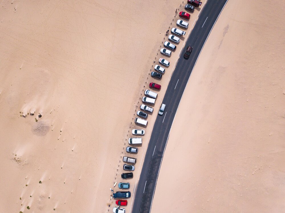 car parking lot near the road in desert, aerial top down view landscape from drone
