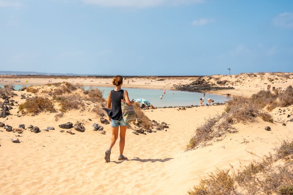 A young tourist visiting La Concha beach on Isla de Lobos, next to the north coast of the island of Fuerteventura, Canary Islands. Spain
