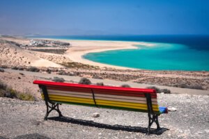 Playa de Sotavento with chair overlooking the water which is bright blue with almost white sand