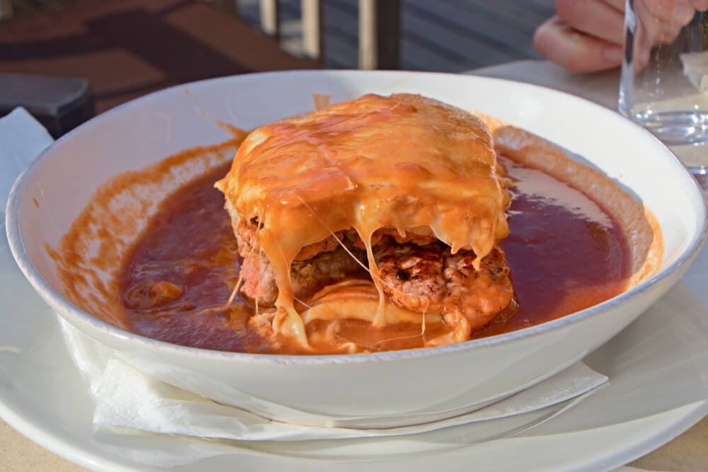 porto's signature sandwich, the francesinha, covered in cheese, filled with meat, and in a tomato beer sauce.