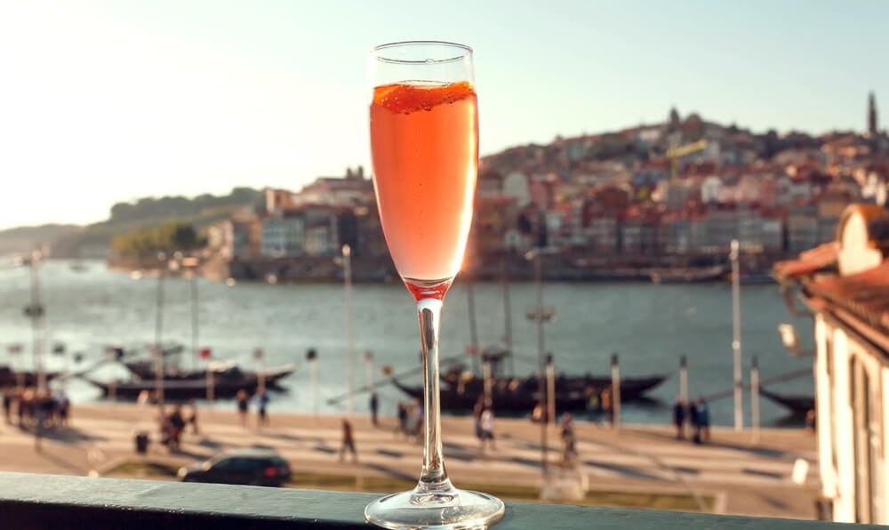 Wine in glass on window sill with cityscape of Porto, Portugal. Cityscape with river Douro and historical areas.
