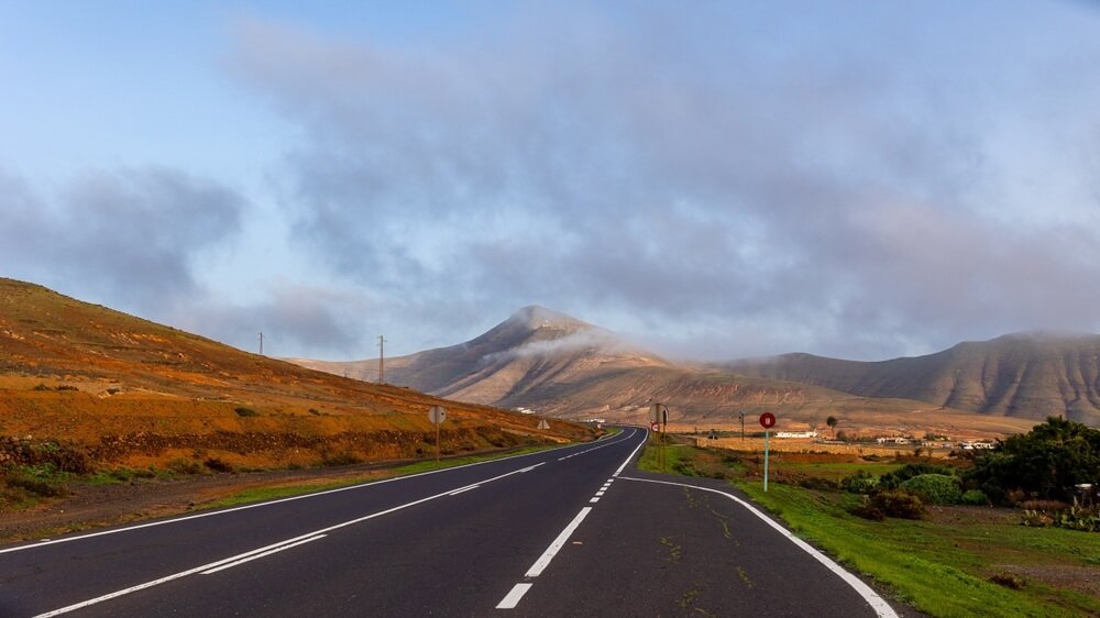 Asphalt road running through the picturesque landscape of Fuerteventura, Canary Islands, Spain  