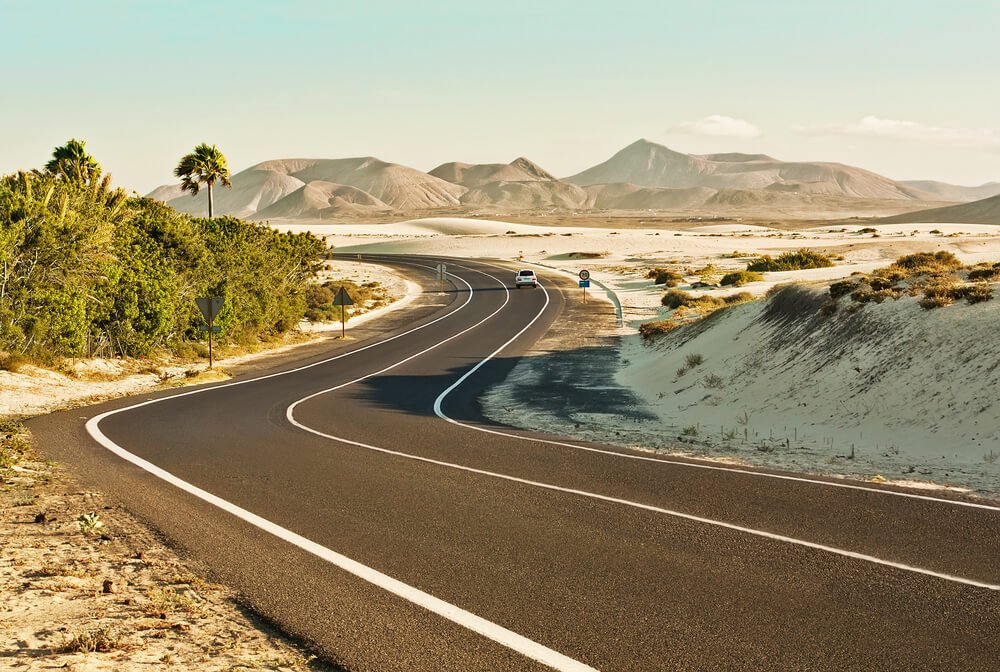 Curvy road through the dunes of Corralejo, Fuerteventura, in the Canary Islands, Spain.
