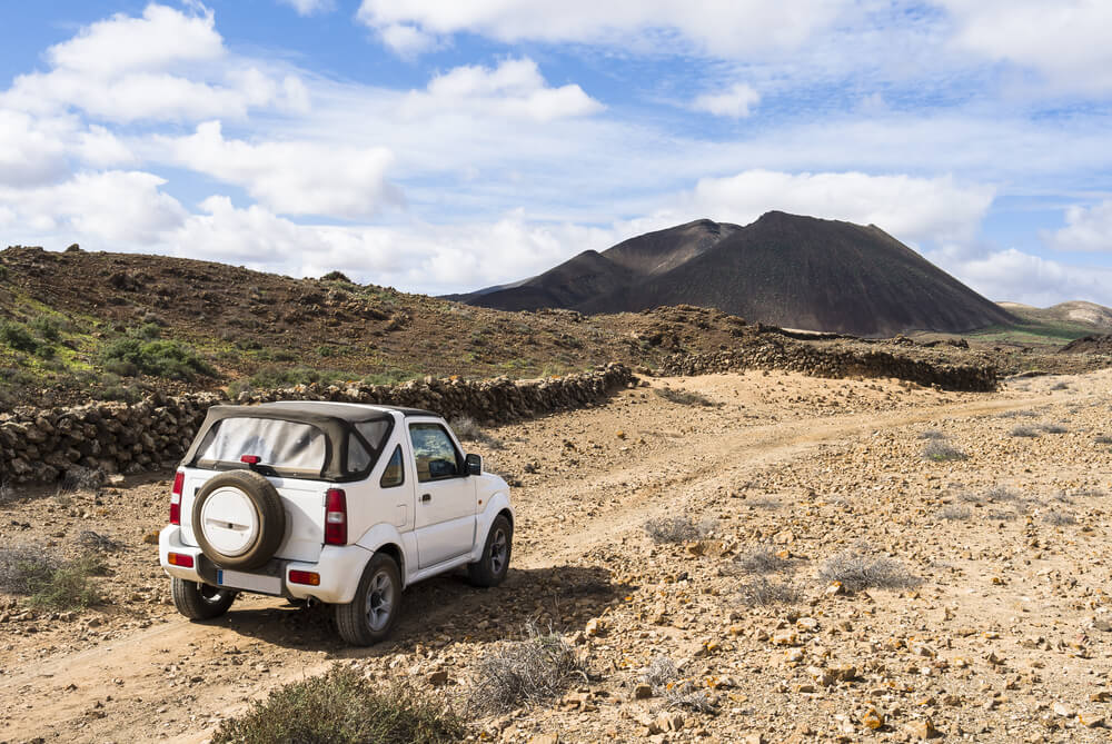 White off road vehicle in the outback of Fuerteventura Canary Islands exploring the country site. 
