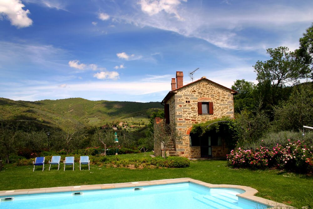 a pool villa in tuscany with loungers and countryside