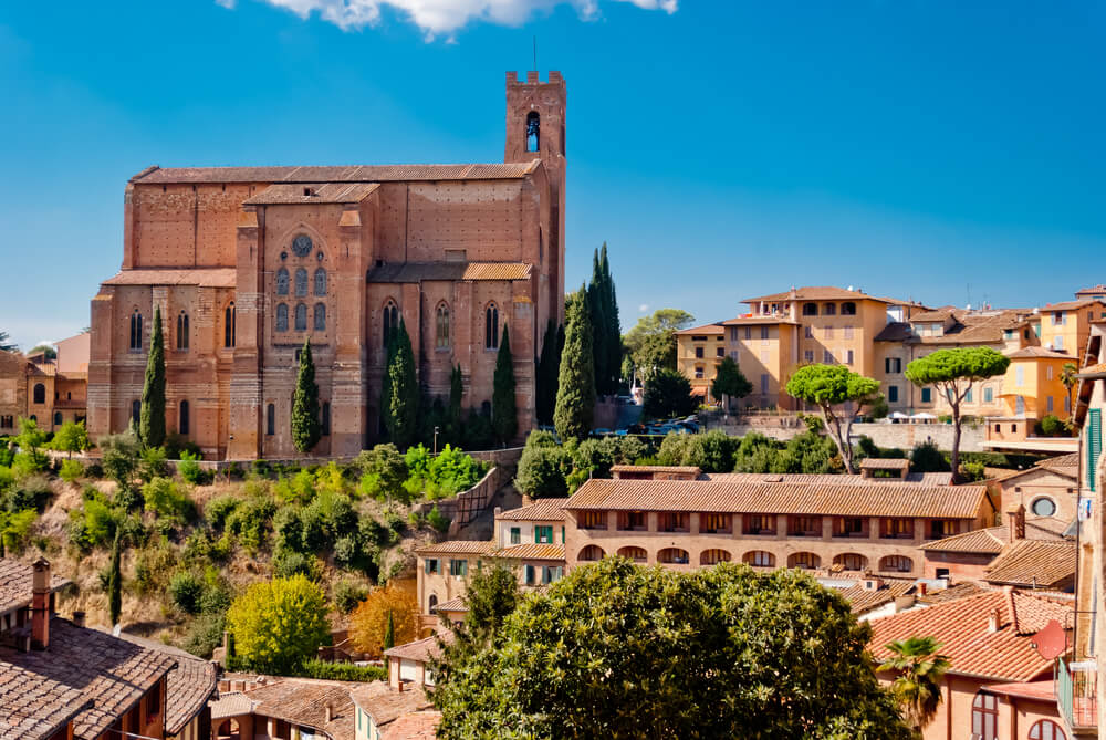 The view from the side profile of San Domenico church, an important landmark in the Tuscan city of Siena, Italy, on a summery day with no clouds in the sky.
