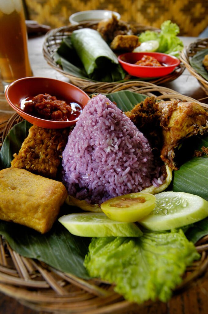 purple rice with other indonesian foods at a local warung (indonesian food eatery)