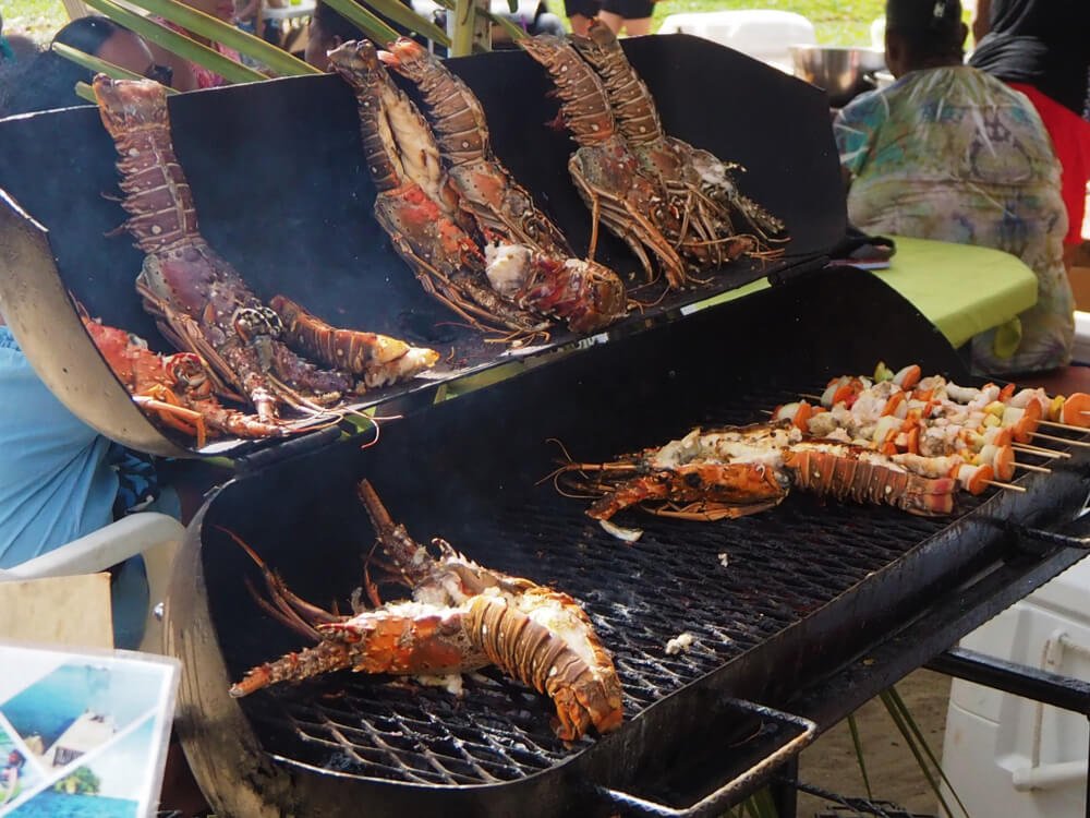 BBQ lobster on a grill in Belize, with the lobsters split in half