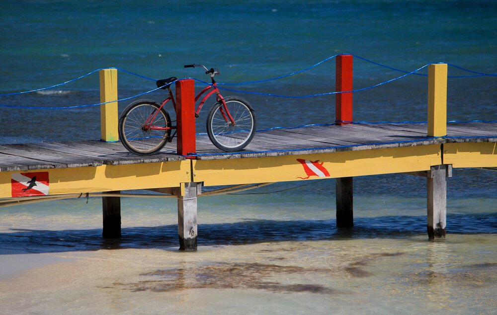 bicycle on a dive shop pier with red and yellow paint in belize