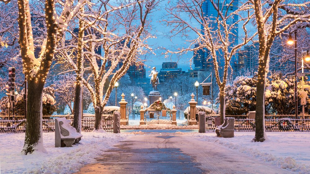 christmas atmosphere in boston park with a statue in the middle of it all dusted in snow