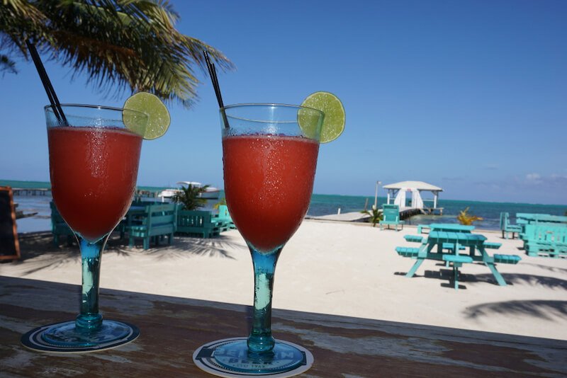 drinks on the beach with blue picnic tables in caye caulker