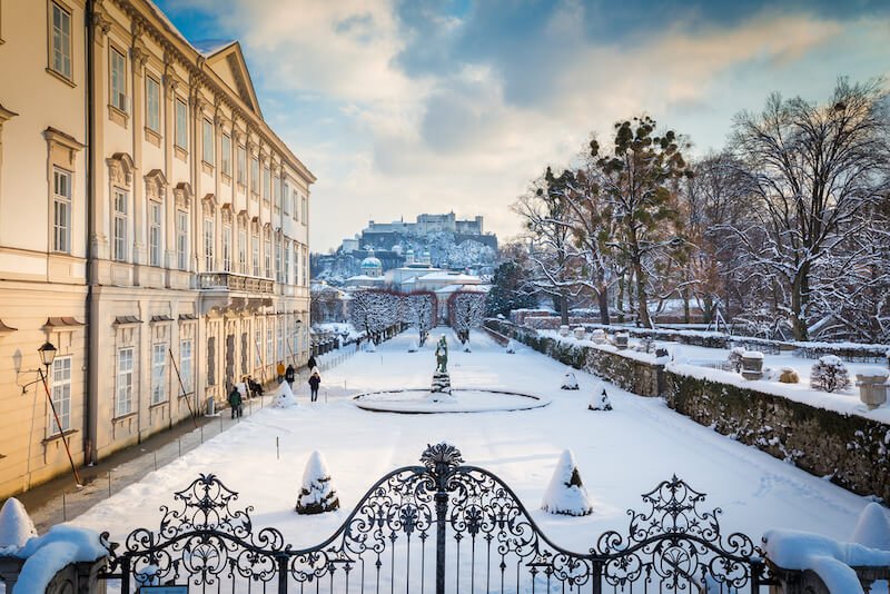 a frosty, wintry scene in the salzburg city center with a frozen garden and fountain